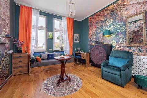 A cosy corner with an armchair and coffee table, where morning coffee tastes even better thanks to large windows and warm light.
