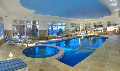Dive into the sunlit indoor pool with serene views.