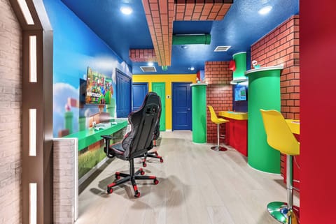 Discover a lively gaming haven with playful decor, bright colors, and a sleek gaming chair. The cheerful bar area invites relaxation and spirited fun, making sure your stay is full of excitement and enjoyable moments.