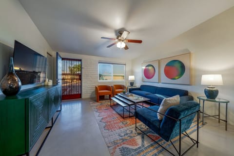 Bright and inviting living room with plenty of comfortable seating, smart TV, and ceiling fan