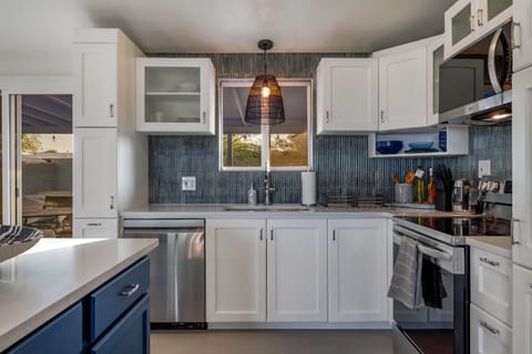 Fully updated kitchen with stainless steel appliances, gorgeous backsplash, plenty of storage, and island with additional seating