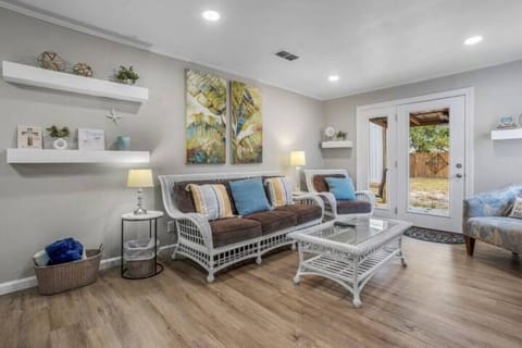 Relax in the inviting living room, adorned with comfortable wicker furniture and cheerful decor, ideal for unwinding after a day of sun and surf.