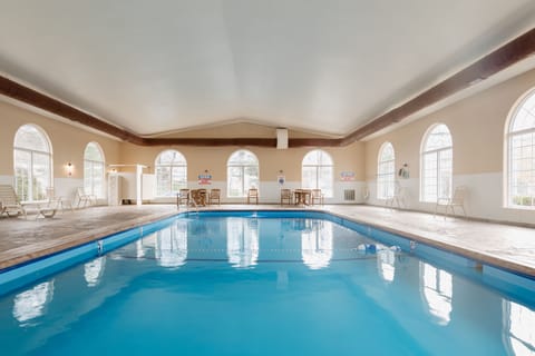 A bright indoor pool with large windows and loungers, perfect for a calm swim or quiet break.
