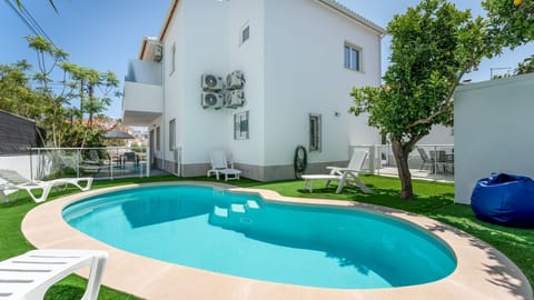 Unwind in your private oasis – this lush backyard features a sparkling pool, sun loungers, and a tranquil garden setting. #PrivatePool #OutdoorLiving #FamilyFriendly