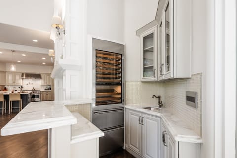 Main Living Area featuring designer furnishings, Smart TV, wet bar area with a wine cooler, and access to the backyard.