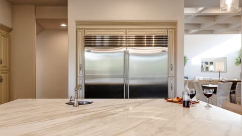 Fully equipped kitchen with stainless steal appliances, mini wine cooler, ice maker, and a kitchen island with bar seating for 4 guests.
