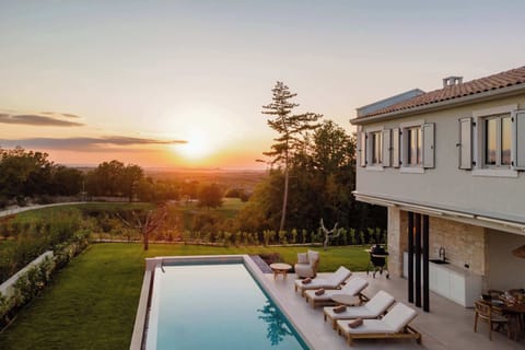 Exterior of the villa with pool and sunset