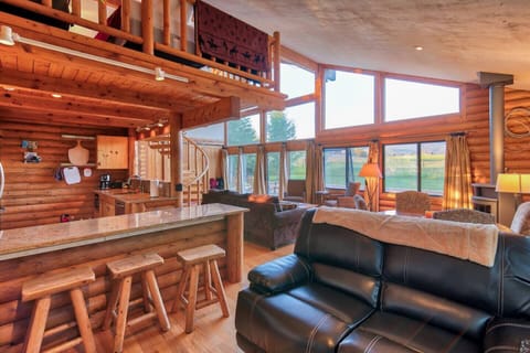 The open concept kitchen and living area features comfortable furniture, stainless steel appliances, granite countertops, and amazing views!