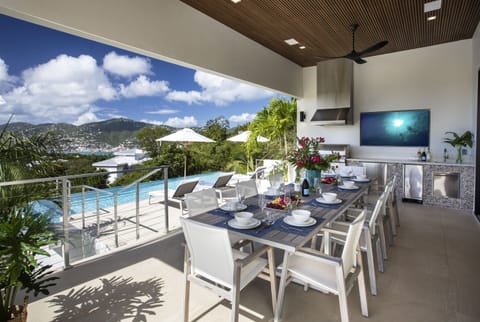 Pool deck with covered outdoor dining area, grill, tv and bar