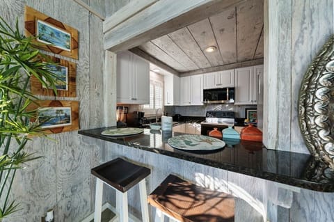 Your coastal-inspired kitchen features granite counters, modern appliances, and charming breakfast bar seating perfect for morning coffee.