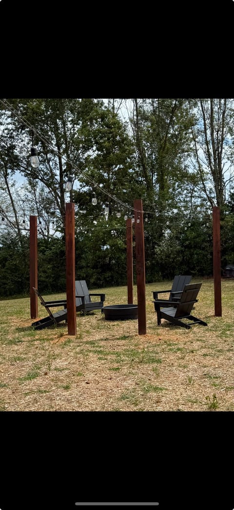 Backyard firepit with 4 chairs and string lights