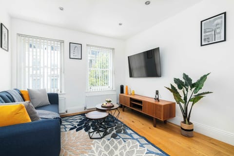 Spacious lounge with vibrant decor, Netflix-ready TV and natural light perfect for relaxing after a day exploring