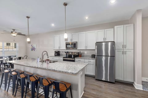 Bright, fully equipped kitchen with a spacious island bar — perfect for cooking, gathering, or enjoying your morning coffee.
