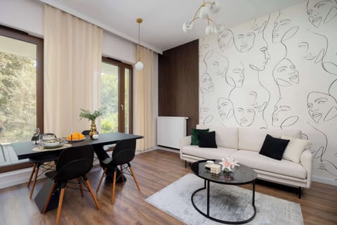 An elegant seating area with a bright sofa, modern décor and a table with chairs, perfect for eating meals.us living room filled with natural light, featuring modern furniture and large windows overlooking the outside greenery.