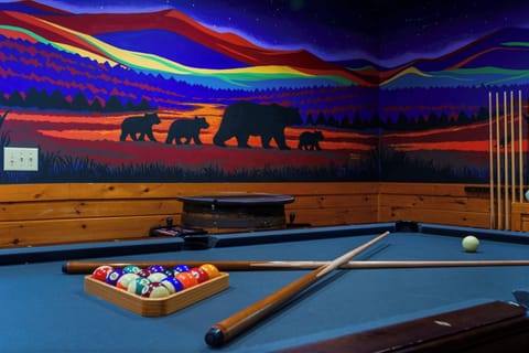 Cozy game room with pool table and stunning mountain bear mural