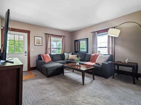 Cozy living room with large sectional sofa, smart TV & board games for family fun ️✨