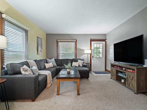 Cozy living room with large sectional sofa, smart TV & board games for family fun ️✨