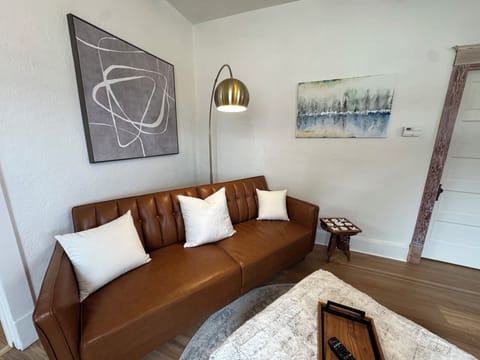 Sleek leather couches, modern artwork, and warm lighting.
