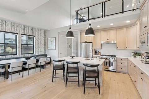 Chef's kitchen with large island, pendant lights, and bar seating.