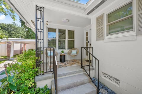 Charming Entrance: Enjoy morning coffee on the stylish patio amidst lush greenery!