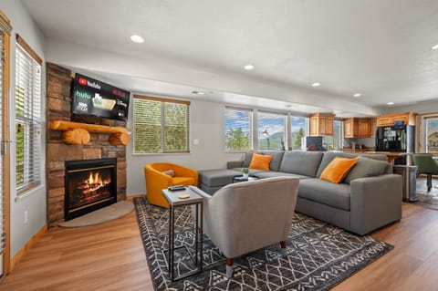 Experience the cozy living room, outfitted with plush seating, a fireplace, a smart TV, and patio doors that frame the breathtaking mountain vistas.