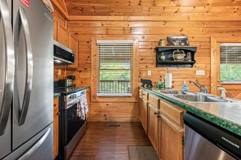 A bright window over the sink frames the trees, making even dish duty feel relaxing.