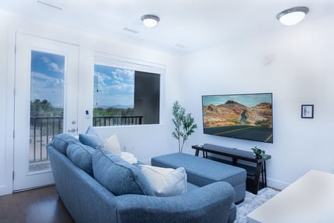 Beautifully designed living room. 65` TV,  sofa and amazing views of mountains and city skyline.