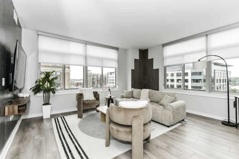 Chic and bright living room with cozy couch, flatscreen Tv and dedicated work station