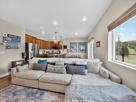 View of the comfortable living room sectional to the dining and kitchen areas