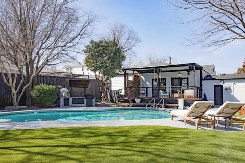 Large covered deck, outdoor kitchen, rolled down sun shade for the deck, outdoor loungers, outdoor games,  Large turf grass, Large pool and hot tub