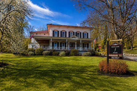 The Keuka Cove House with front lawn and wraparound porch.