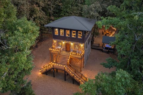 Golden-hour lighting highlights this elevated cabin framed by tall pines.