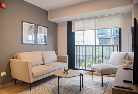 Cozy living room with beige sofas, coffee tables, and large window.