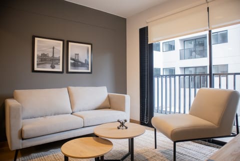 Living room with two comfortable armchairs, a coffee table, and natural light streaming through the windows.