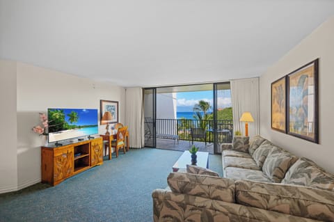 Bright and welcoming living space with a queen-size sleeper sofa and peak-a-boo ocean + tropical greenery views — perfect for families or groups.