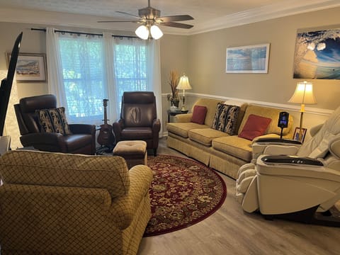 Living room features a 70 inch TV, seating for 7, & full body massage chair  