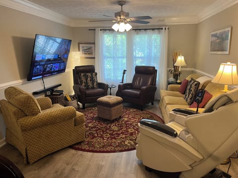 Living room features a 70 inch TV, seating for 7, & full body massage chair  
