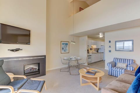 Elevate your experience in the airy living area, showcasing a flat-screen TV, a dining table, and an inviting ambiance with panoramic ocean views.