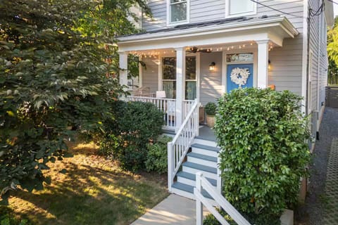 Cozy nook on the front porch w seating, string lights, ceiling fan!