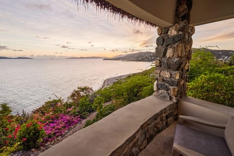 Experience breathtaking 180º sunset ocean views from the cozy stone terrace of 'Grace', surrounded by vibrant tropical gardens.