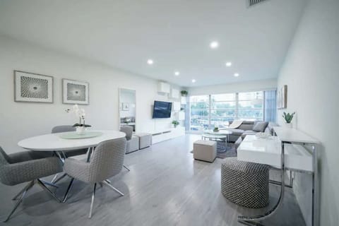 Open living and dining space with sofa, desk, and big windows