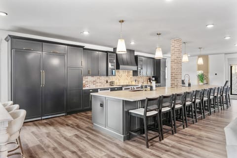 This gourmet kitchen stuns with sleek black cabinetry, a massive island with bar seating, and high-end appliances. Designed for both function and flair, it’s a chef’s dream and a host’s paradise for entertaining in style.