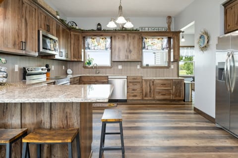 Expansive kitchen featuring stainless steel appliances, ample cabinet space, and plenty of natural light for a welcoming cooking experience.