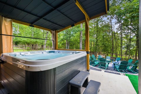 Bubbles, warmth, and tranquility! Indulge in a relaxing dip in our private hot tub, nestled under a cozy cover with lush greenery all around. Your ultimate escape is here.