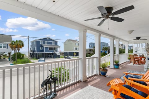 Relax on your covered porch with ceiling fans, comfortable seating, and beautiful coastal home views in this peaceful beachside neighborhood.