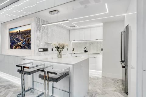 1st FLOOR: FULL BAR KITCHEN features full size Viking fridge, Viking drawer microwave, 2 burner cook top, sink, ceiling mounted champaign flutes, and bar seating for 2. Full kitchen accessories, cutlery, plates, cookware available.  