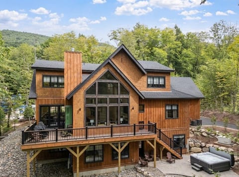 Beautiful mountain cabin surrounded by nature, featuring expansive windows, outdoor decks, and a peaceful New Hampshire setting ideal for a relaxing getaway.