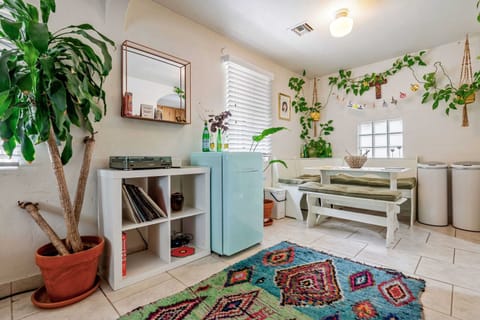 Sip, spin, and savor in this charming corner featuring a cozy breakfast bench, lush greenery, and a vintage-style record setup—plus a pastel mini fridge to keep your drinks chill and your style cooler.