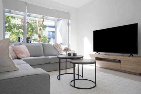 Bright, cozy living room with modern decor and large sunlit windows.