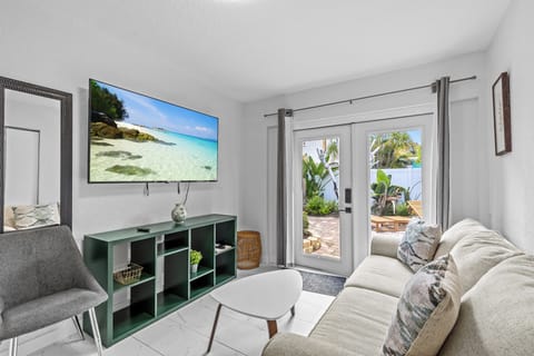 Entrance with French doors and large smart TV.